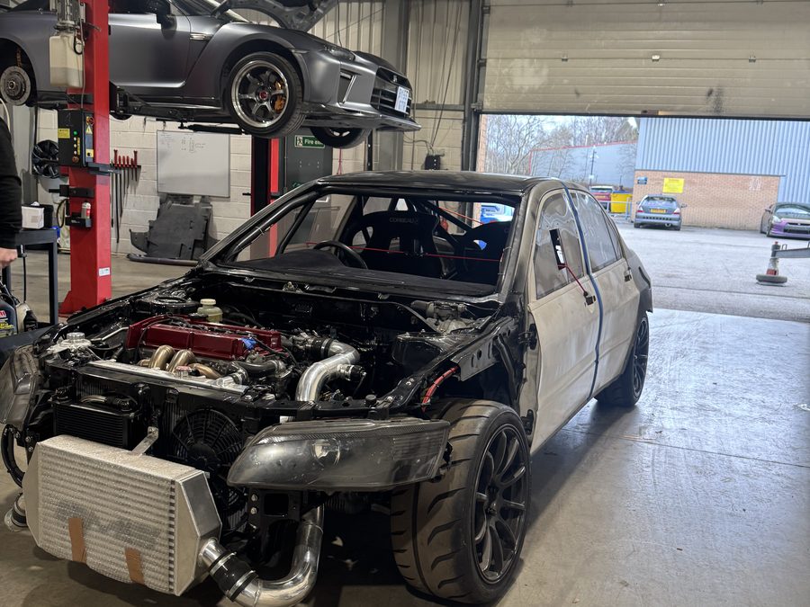 FIA-spec Mitsubishi Evo rally car stripped to the shell with a large intercooler fitted